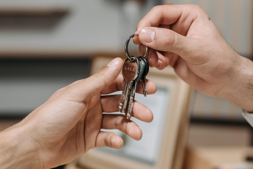 pexels-photo-8112169-8112169 A close-up image of two hands exchanging a set of keys indoors.